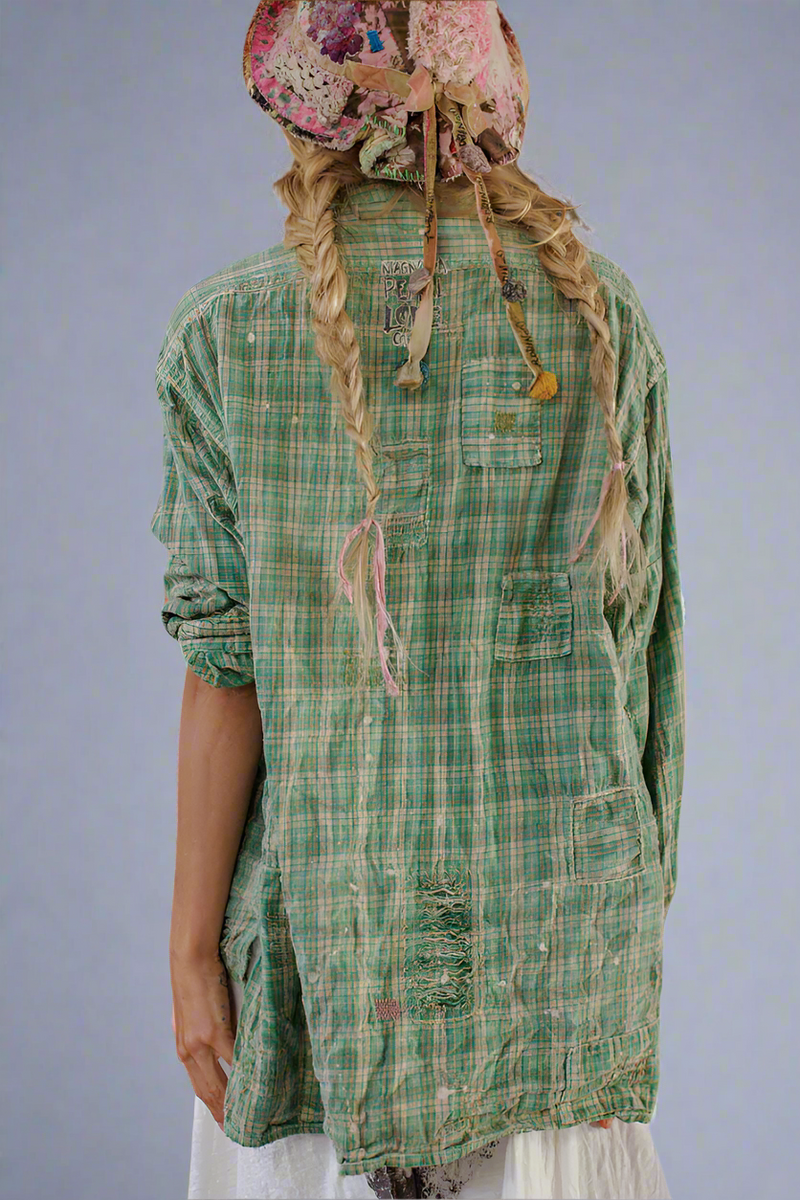 Person wearing a green plaid shirt and colorful headscarf on a white background