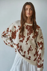 Woman wearing a patterned sweater against a plain background