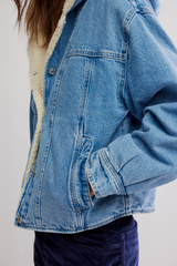 Blue denim jacket with sherpa lining on a white background