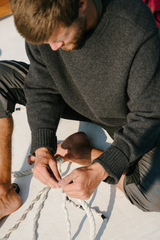 Person tying ropes on a boat