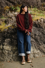 Woman standing against a rocky wall on a beach