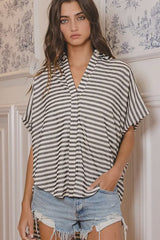 Woman wearing a striped shirt and denim shorts in a decorative room.