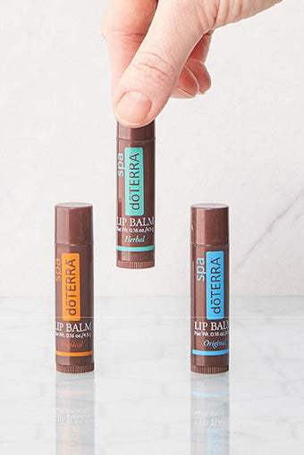 Three lip balm sticks with 'DoTerra' branding on a white background