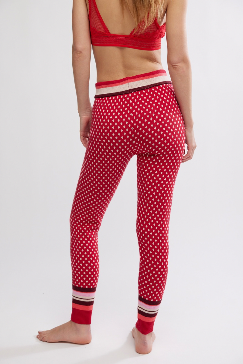 Person wearing red polka dot leggings with a white background
