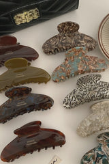 Collection of variously designed hair clips on a white surface