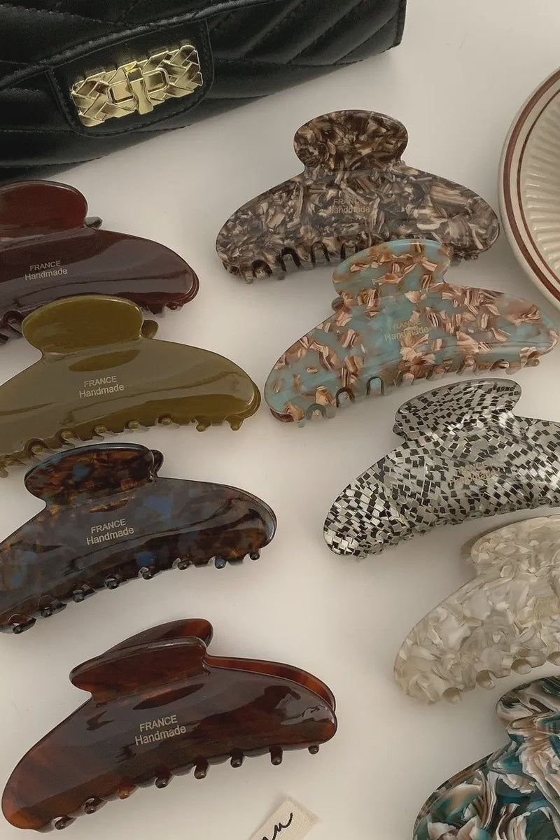 Collection of variously designed hair clips on a white surface