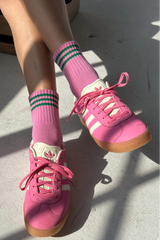 Pink sneakers and socks on a light gray surface