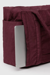 Maroon bag with a silver laptop inside on a white background