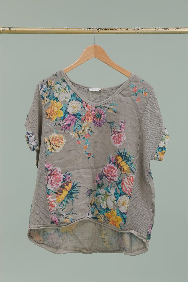 Floral-patterned shirt on a hanger against a plain background