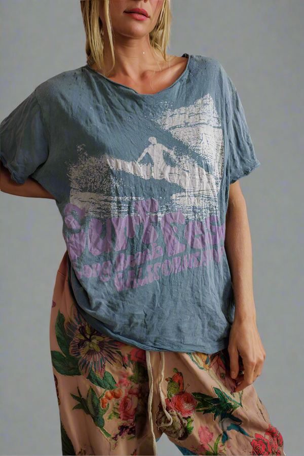 Person wearing a blue graphic t-shirt with floral pants 
