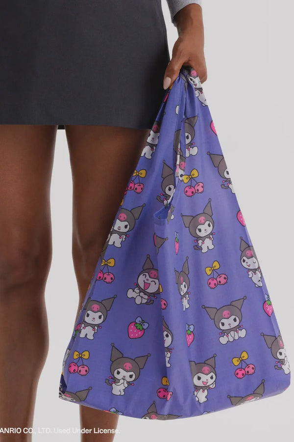 Person holding a purple bag with Kuromi cartoon character pattern on a plain background