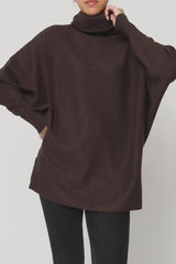 Brown turtleneck sweater worn by a person on a plain background