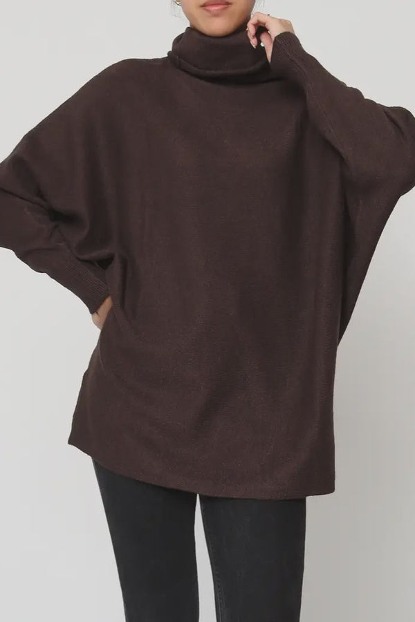 Brown turtleneck sweater worn by a person on a plain background