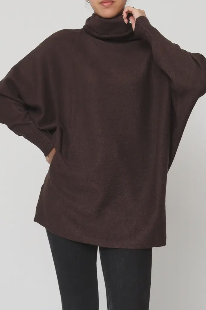 Brown turtleneck sweater worn by a person on a plain background
