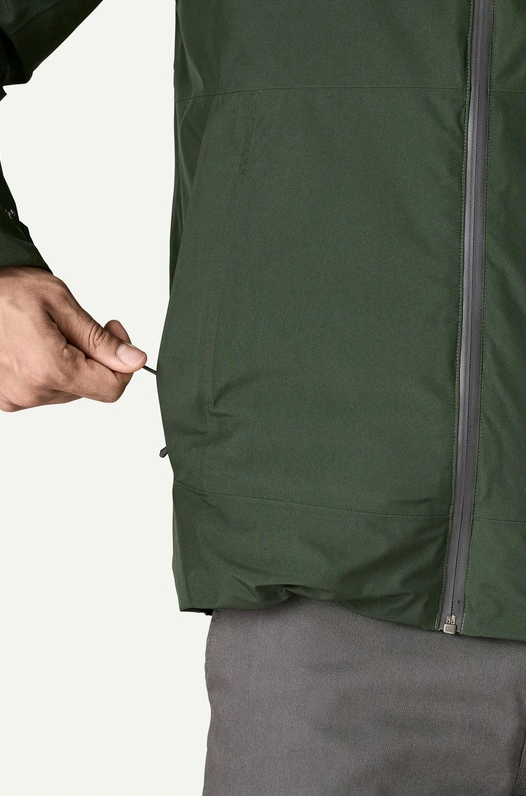 Person wearing a green jacket with a close-up of the zipper area on a white background
