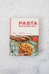 Cookbook titled 'Pasta Grannies' on a marble surface