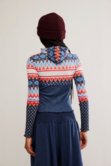 Person wearing a colorful patterned sweater with a plain background