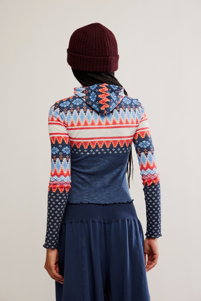 Person wearing a colorful patterned sweater with a plain background