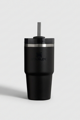 Black Stanley tumbler with a silver lid on a light gray background
