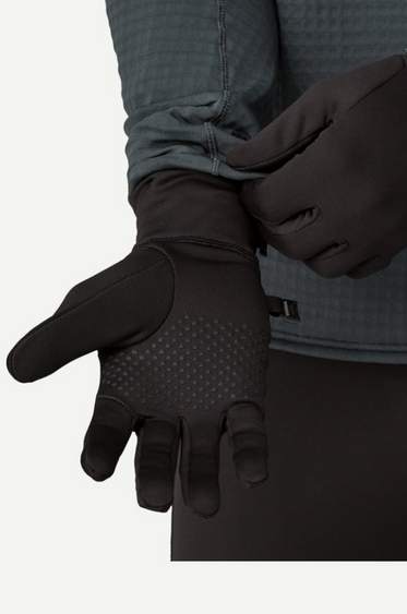 Black gloves being worn with a gray jacket on a white background