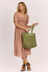Woman holding a green bag against a white background