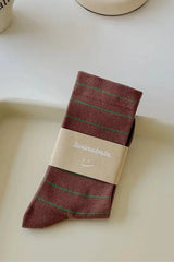 Packaged sock with brand label on a white tray