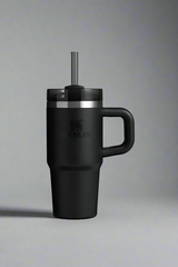 Black insulated mug with handle and straw lid on a light gray background