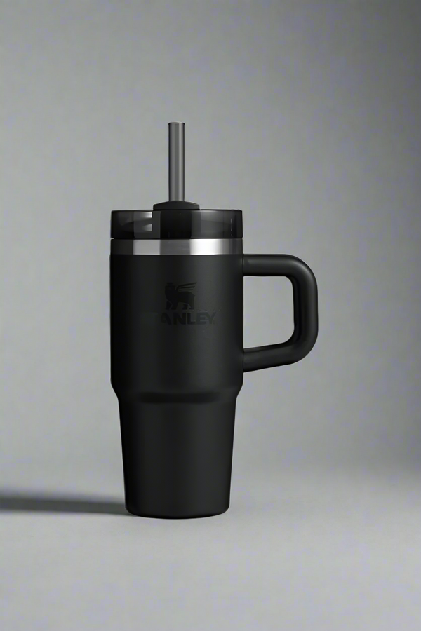 Black insulated mug with handle and straw lid on a light gray background