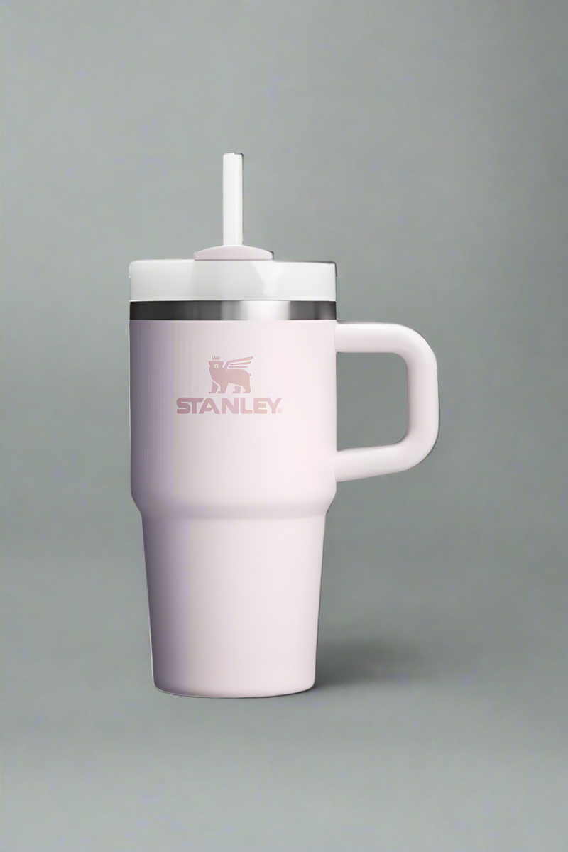 Pink insulated mug with handle and straw lid on a light gray background