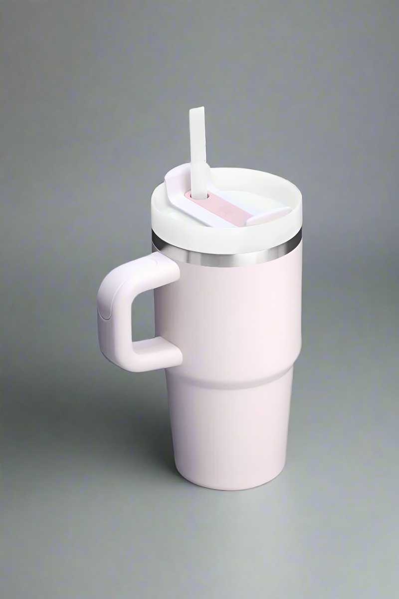 Light pink travel mug with a silver rim on a light gray background