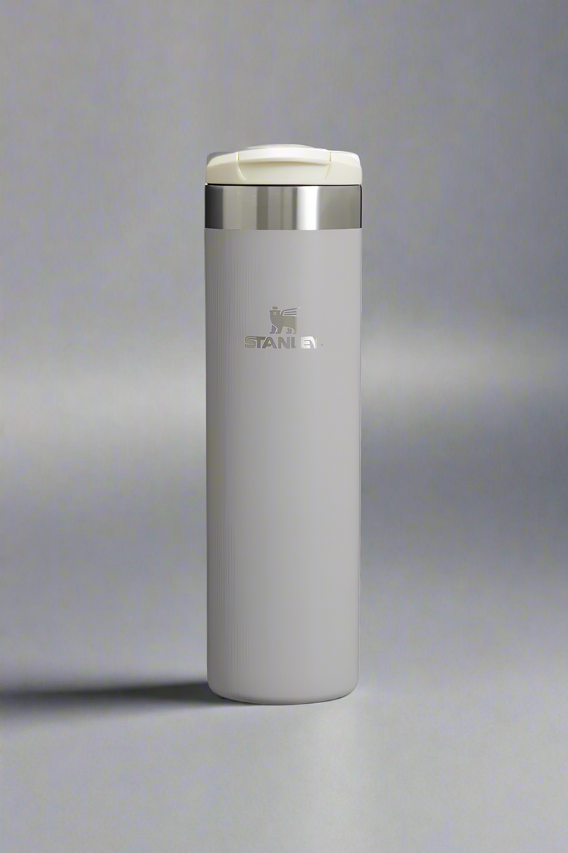 Gray insulated tumbler with a silver lid on a white background