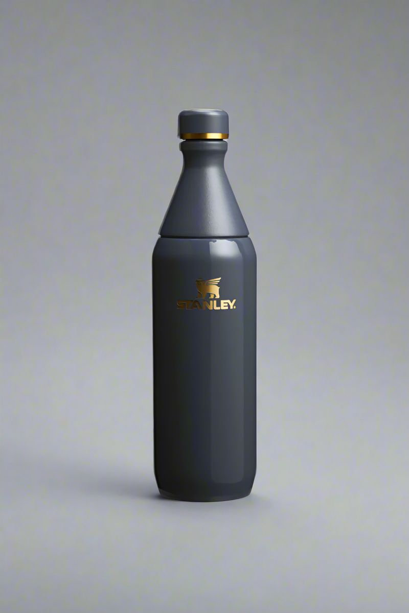 Dark blue water bottle with a gold cap on a light gray background