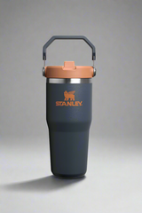 Stanley tumbler with a gray body and brown lid on a light gray background