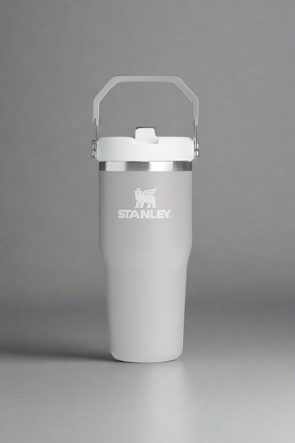 Gray Stanley tumbler with a white lid on a light gray background
