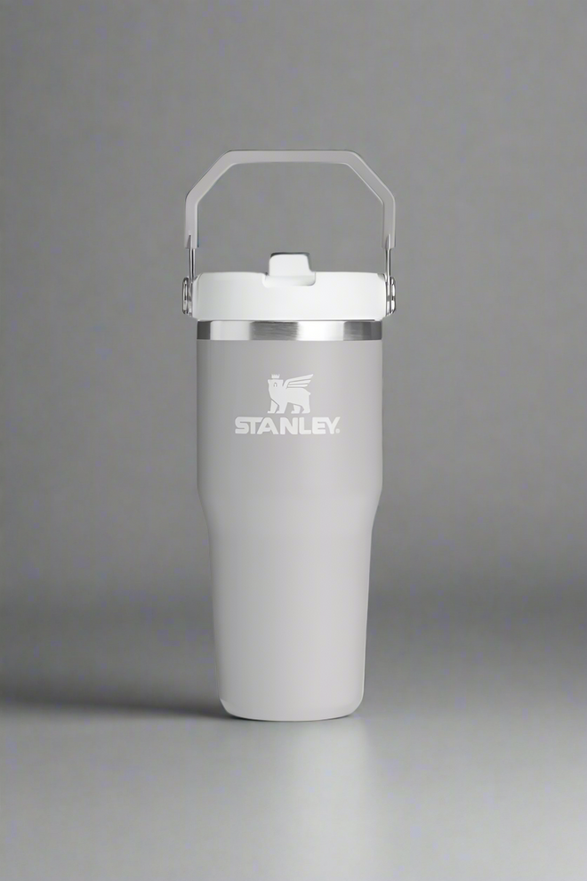 Gray Stanley tumbler with a white lid on a light gray background
