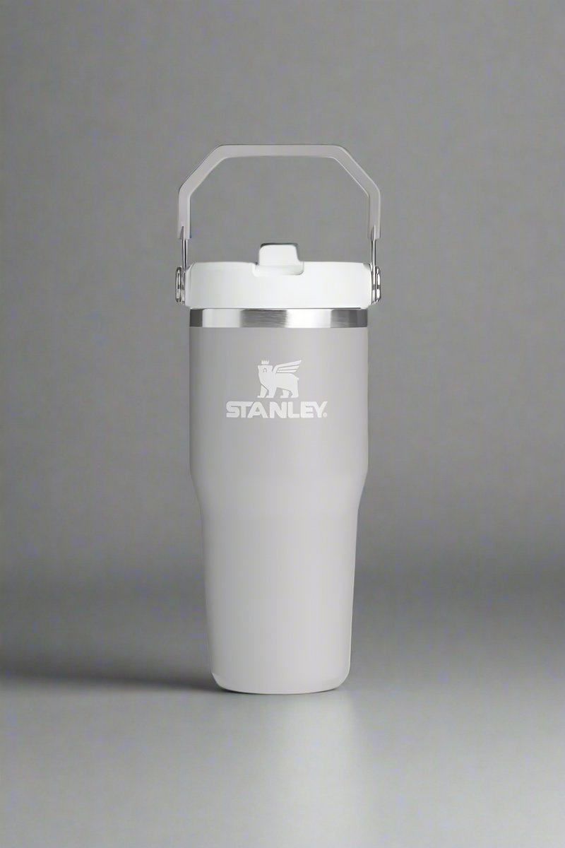 Gray Stanley tumbler with a white lid on a light gray background