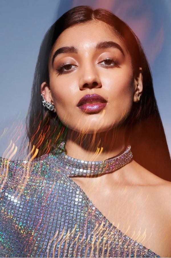 Woman wearing a sparkling silver outfit with a blurred background